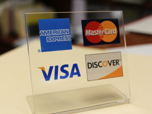 A sign showing four major credit cards accepted at this location.